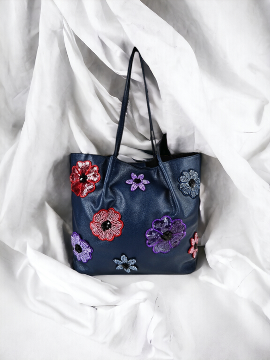 A ladies navy blue floral tote bag on plain white background. 