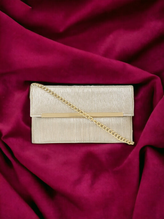 A gold clutch on red sheet. 