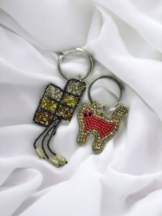 Two keychains of Vdesi India on a plain white background. 