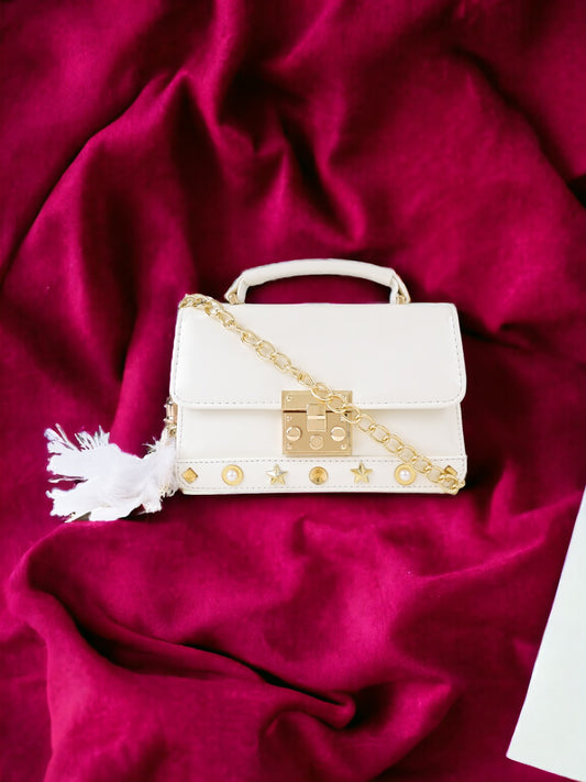 A Vdesi white ladies sling bag on a plain red sheet. 