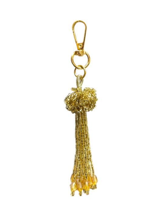 Elevate your style and showcase your impeccable taste with this chic and versatile gold tassel bag charm.