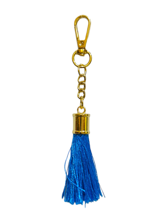 A blue tassel charm crafted with care, its soft blue tassel add elegance to any bag.