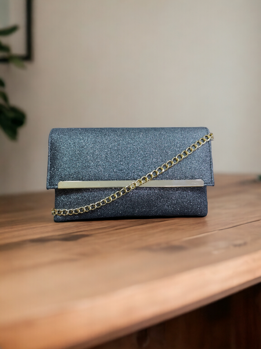 A Vdesi grey envelope clutch on a wooden surface. 