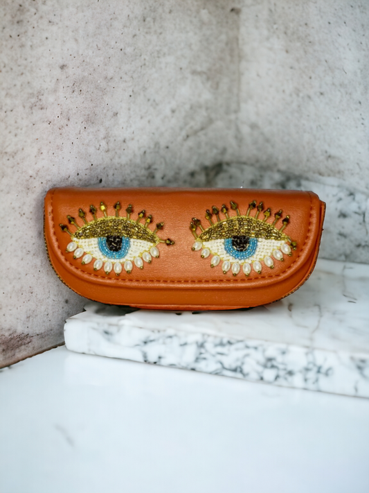 A ladies sunglass case with pretty eyes on it. 
