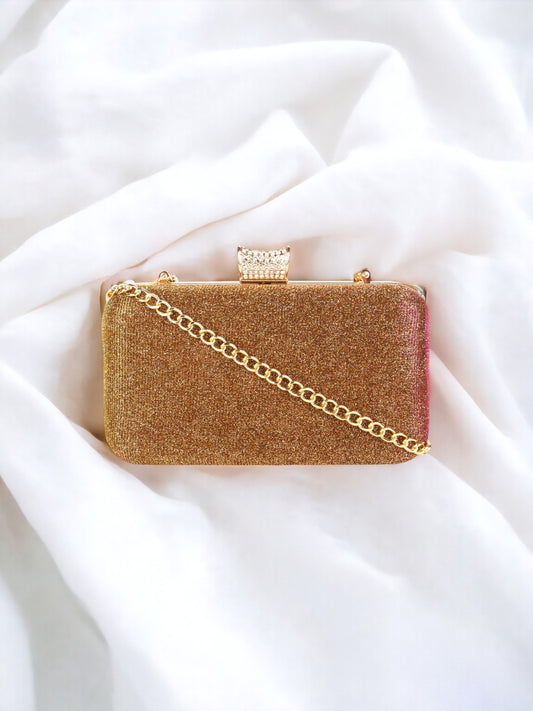 A gold clutch on a plain white background. 